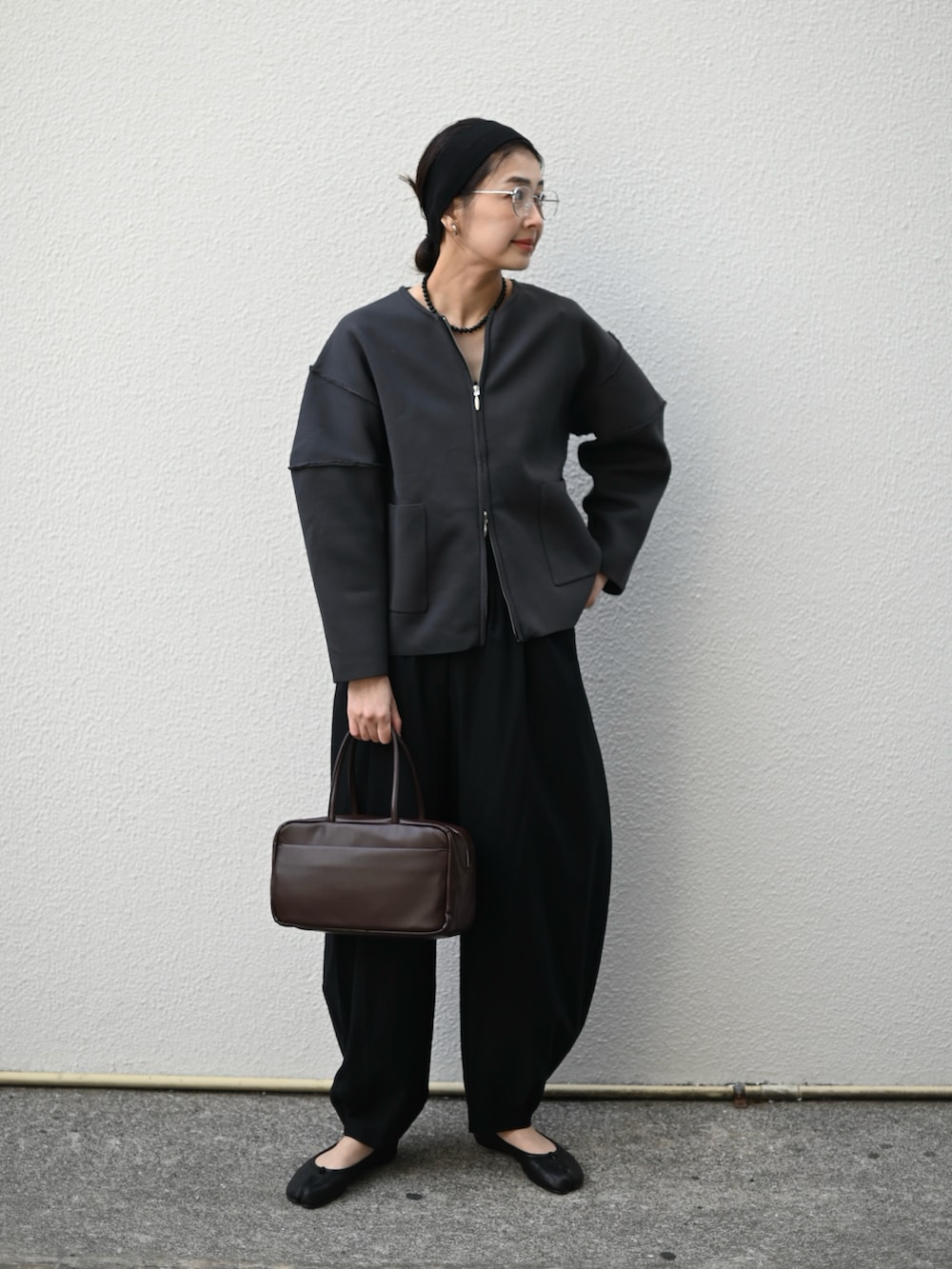 グレー系のカーディガン/ボレロ、ブラウン系のハンドバッグ、ブラック系のスラックスを着用したレディースの冬コーディネートの5枚目の写真