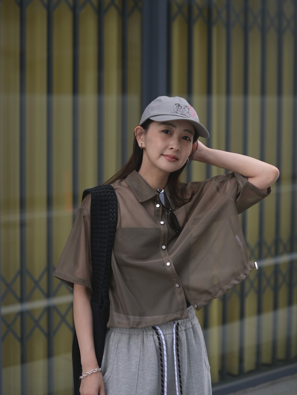 グレー系のスウェットパンツ、ブラック系のトートバッグ、グレー系のキャップを着用したレディースの夏コーディネートの2枚目の写真