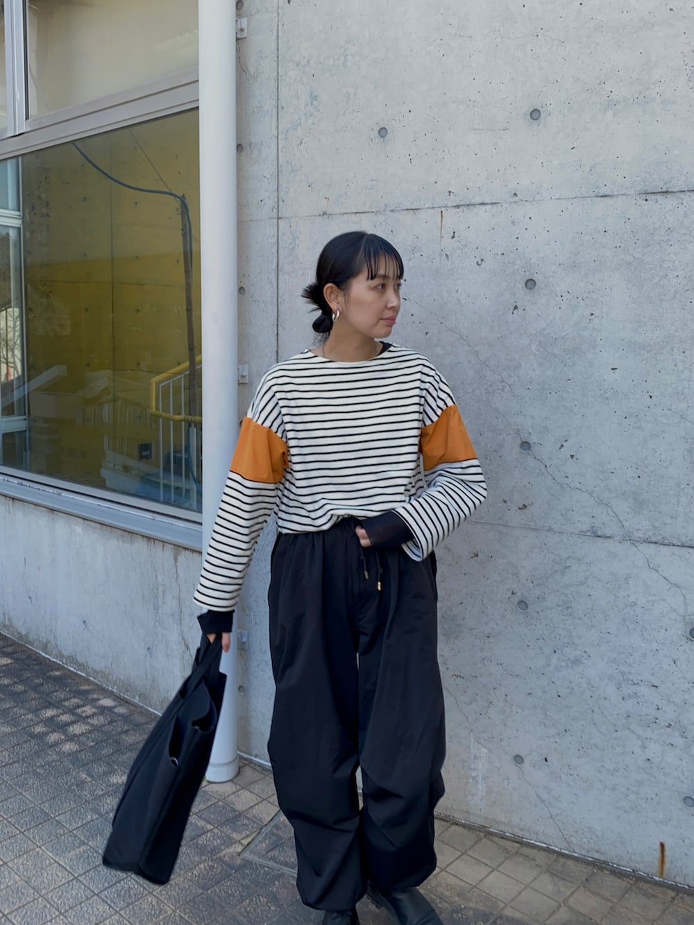 ブラック系のその他パンツ、ブラック系のTシャツ/カットソー、ブラック系のトートバッグを着用したレディースの春コーディネートの4枚目の写真