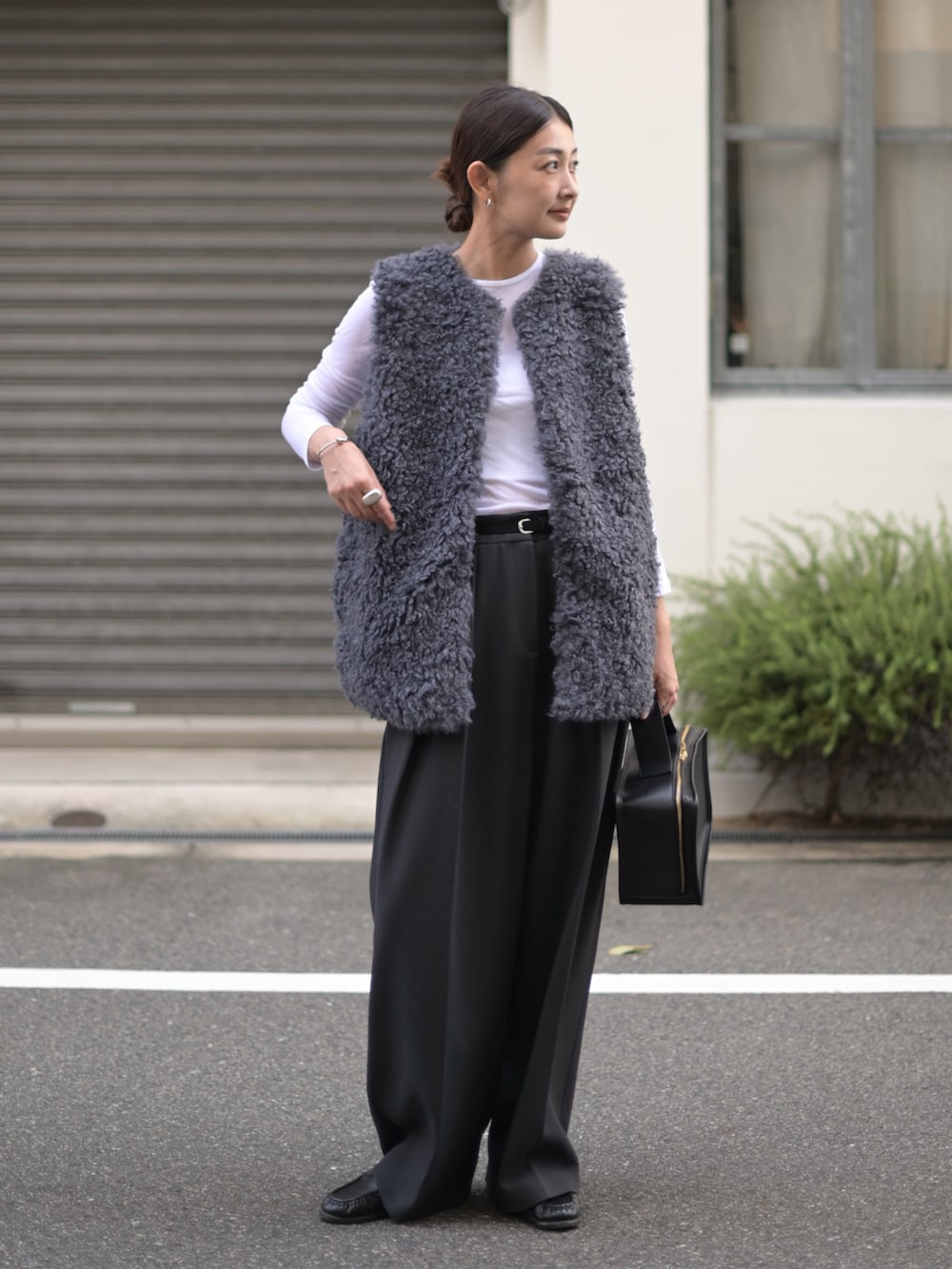 グレー系のベスト、グレー系のその他パンツ、ブラック系のローファーを着用したレディースの秋コーディネートの2枚目の写真