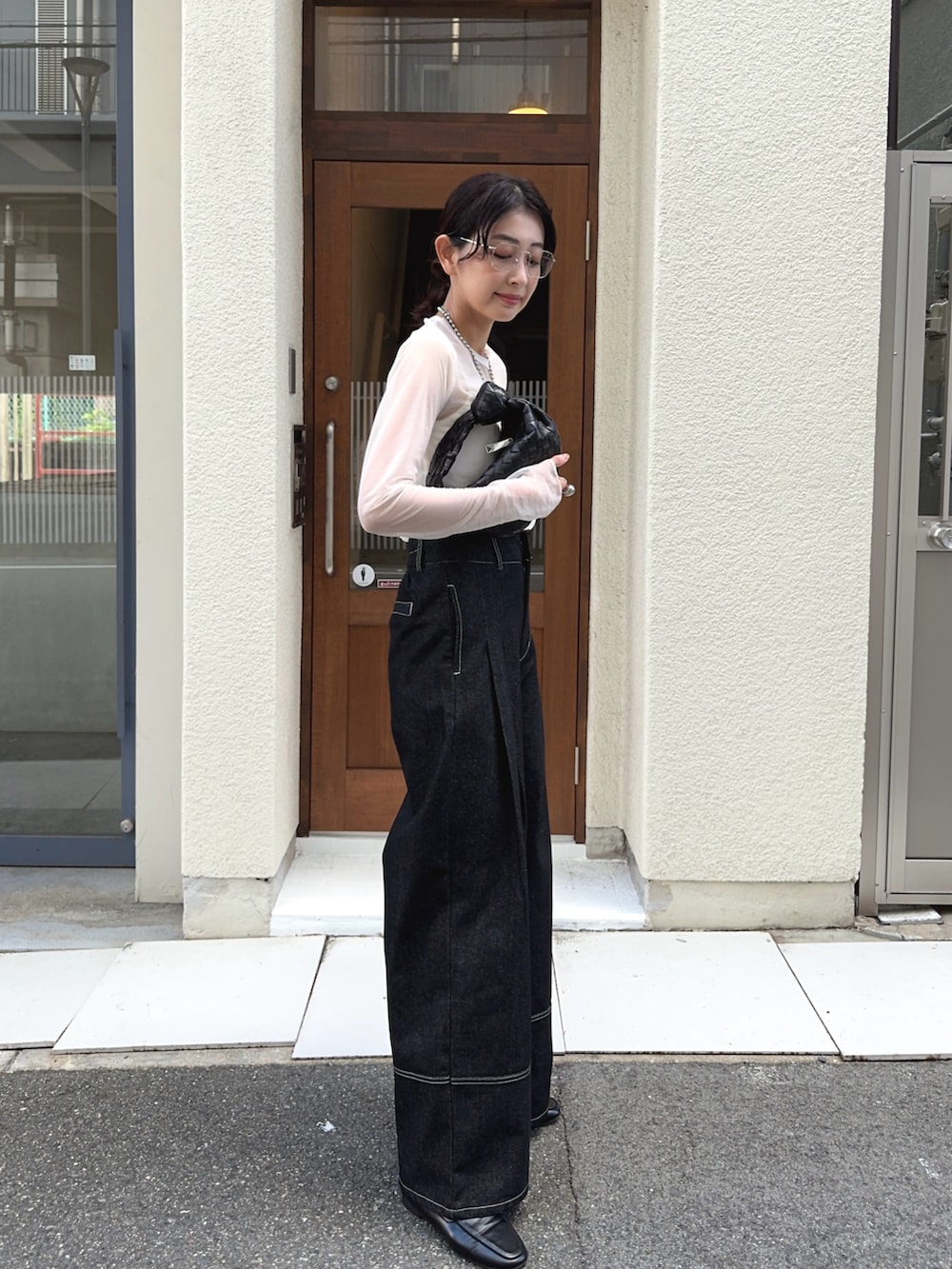 ブラック系のデニムパンツ、ホワイト系のキャミソール、ホワイト系のTシャツ/カットソーを着用したレディースの秋コーディネートの3枚目の写真