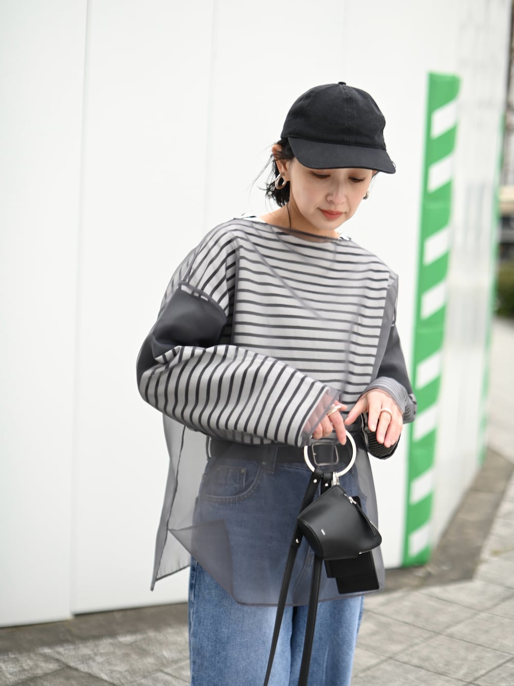 グレー系のシャツ/ブラウス、ブラック系のTシャツ/カットソー、ブルー系のデニムパンツを着用したレディースの春コーディネートの2枚目の写真