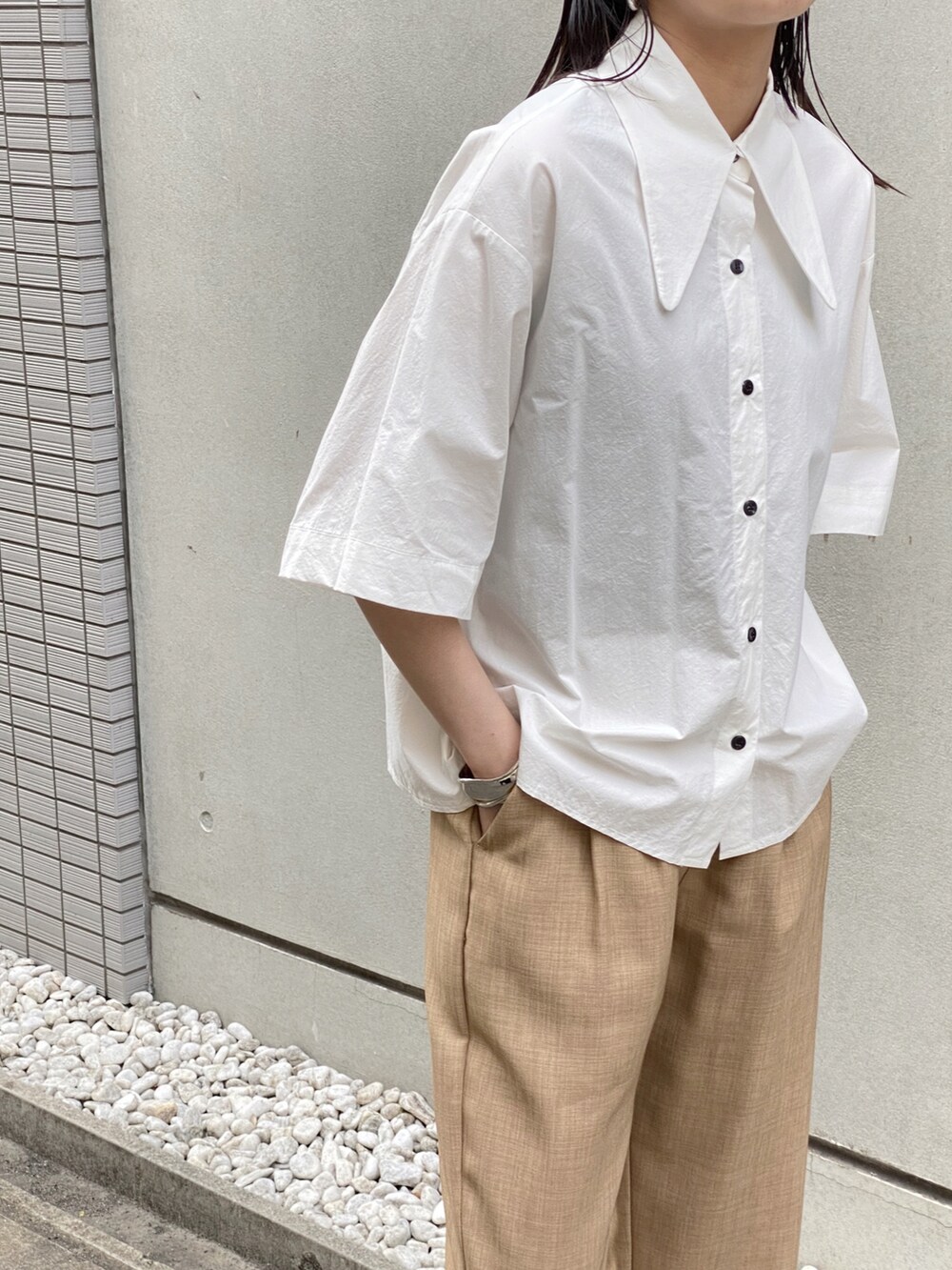 ホワイト系のシャツ/ブラウス、ブラック系のハンドバッグ、シルバー系のネックレスを着用したレディースの夏コーディネートの2枚目の写真