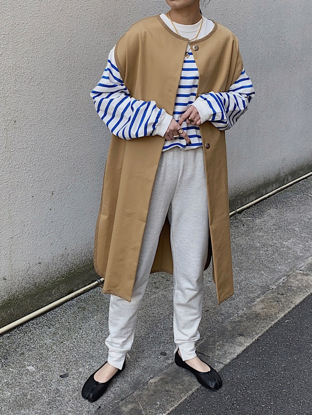 ベージュ系のその他アウター、ブルー系のTシャツ/カットソー、ブラック系のバレエシューズを着用したレディースの春コーディネートの2枚目の写真