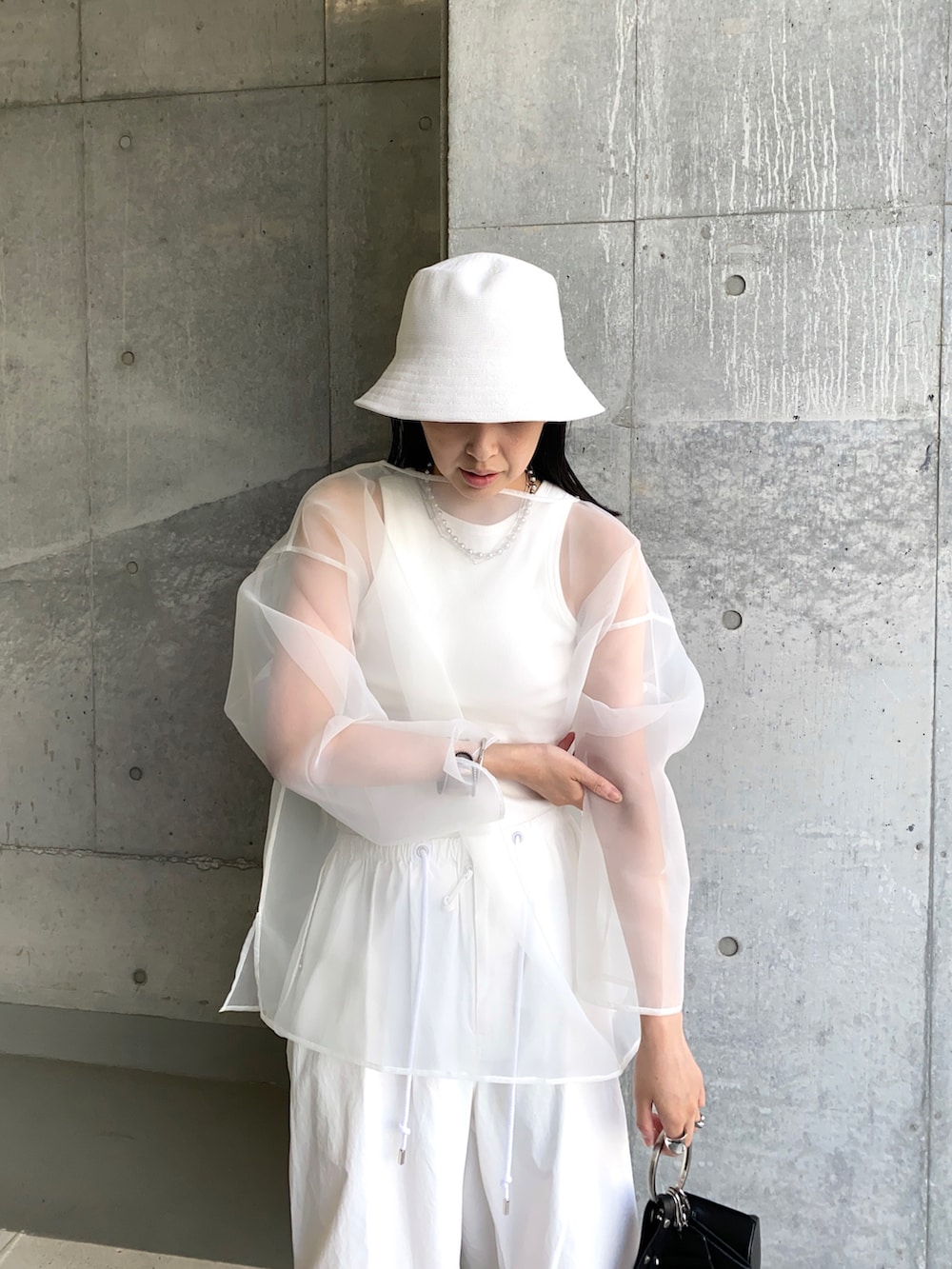 ホワイト系のその他パンツ、ブラック系のショルダーバッグ、ホワイト系のシャツ/ブラウスを着用したレディースの夏コーディネートの2枚目の写真