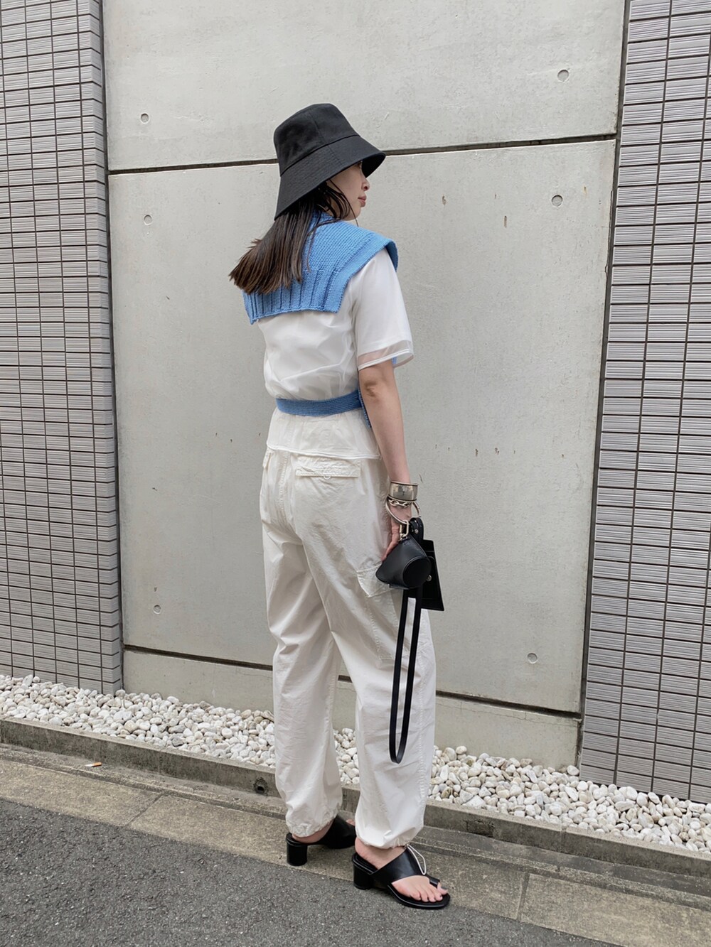 ブルー系のベスト、ホワイト系のその他パンツ、ブラック系のショルダーバッグを着用したレディースの夏コーディネートの2枚目の写真