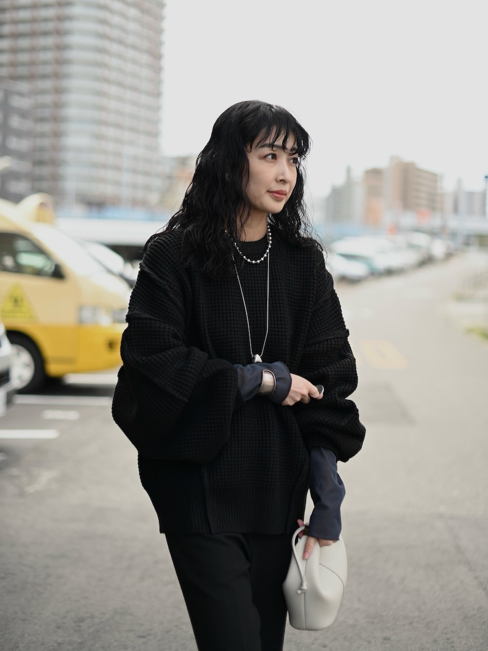 ブラック系のニット/セーター、グレー系のTシャツ/カットソー、ブラック系のブーツを着用したレディースの秋コーディネートの3枚目の写真