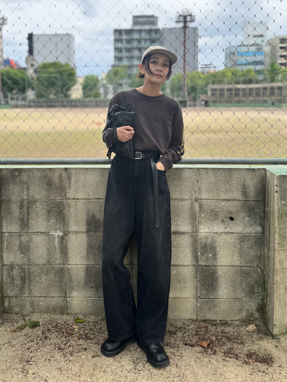 ブラック系のデニムパンツ、グレー系のTシャツ/カットソー、ブラック系のローファーを着用したレディースの春コーディネートの3枚目の写真