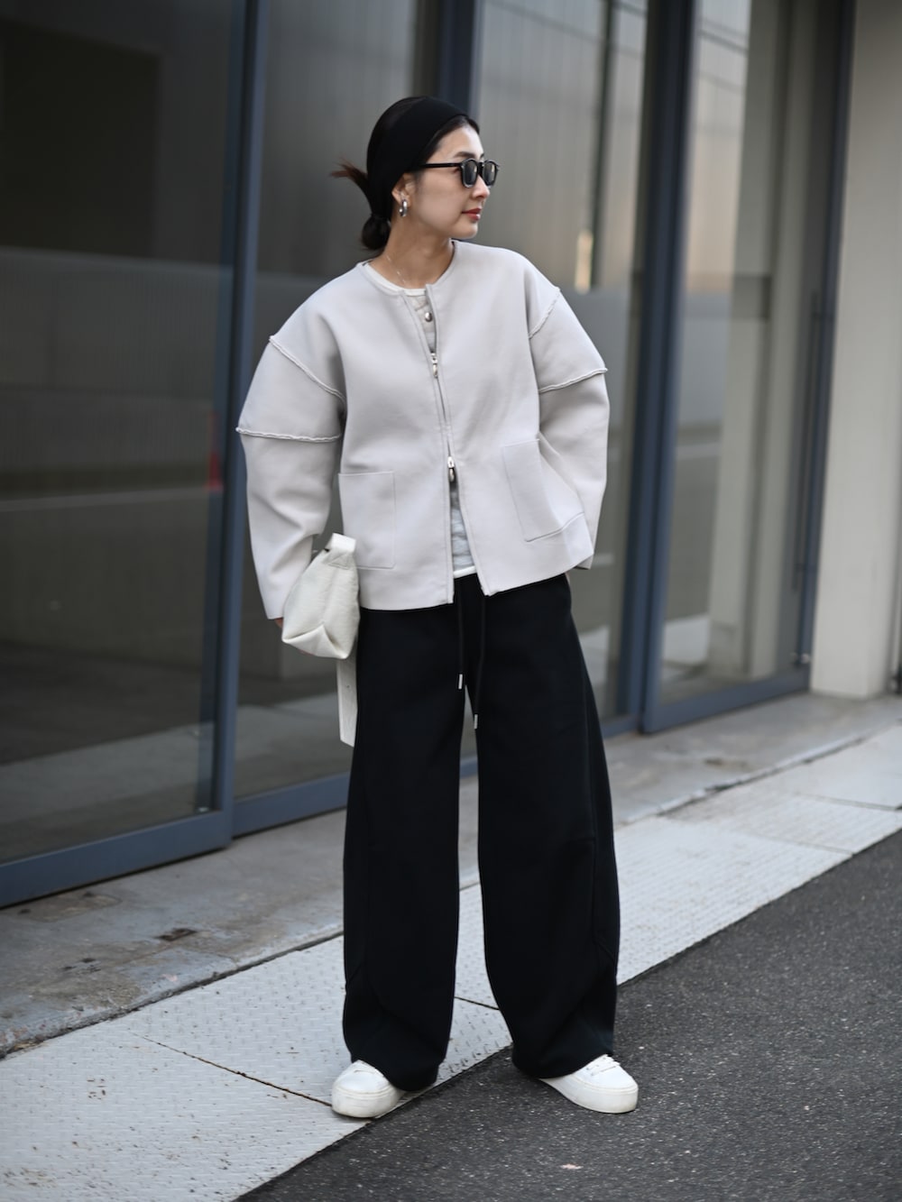 グレー系のカーディガン/ボレロ、ブラック系のスウェットパンツ、ホワイト系のスニーカーを着用したレディースの冬コーディネートの2枚目の写真