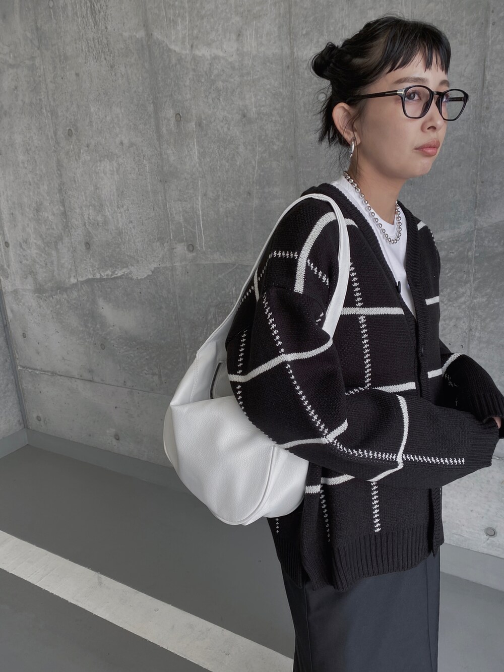 ブラック系のカーディガン/ボレロ、ブラック系のスカート、ホワイト系のトートバッグを着用したレディースの冬コーディネートの4枚目の写真