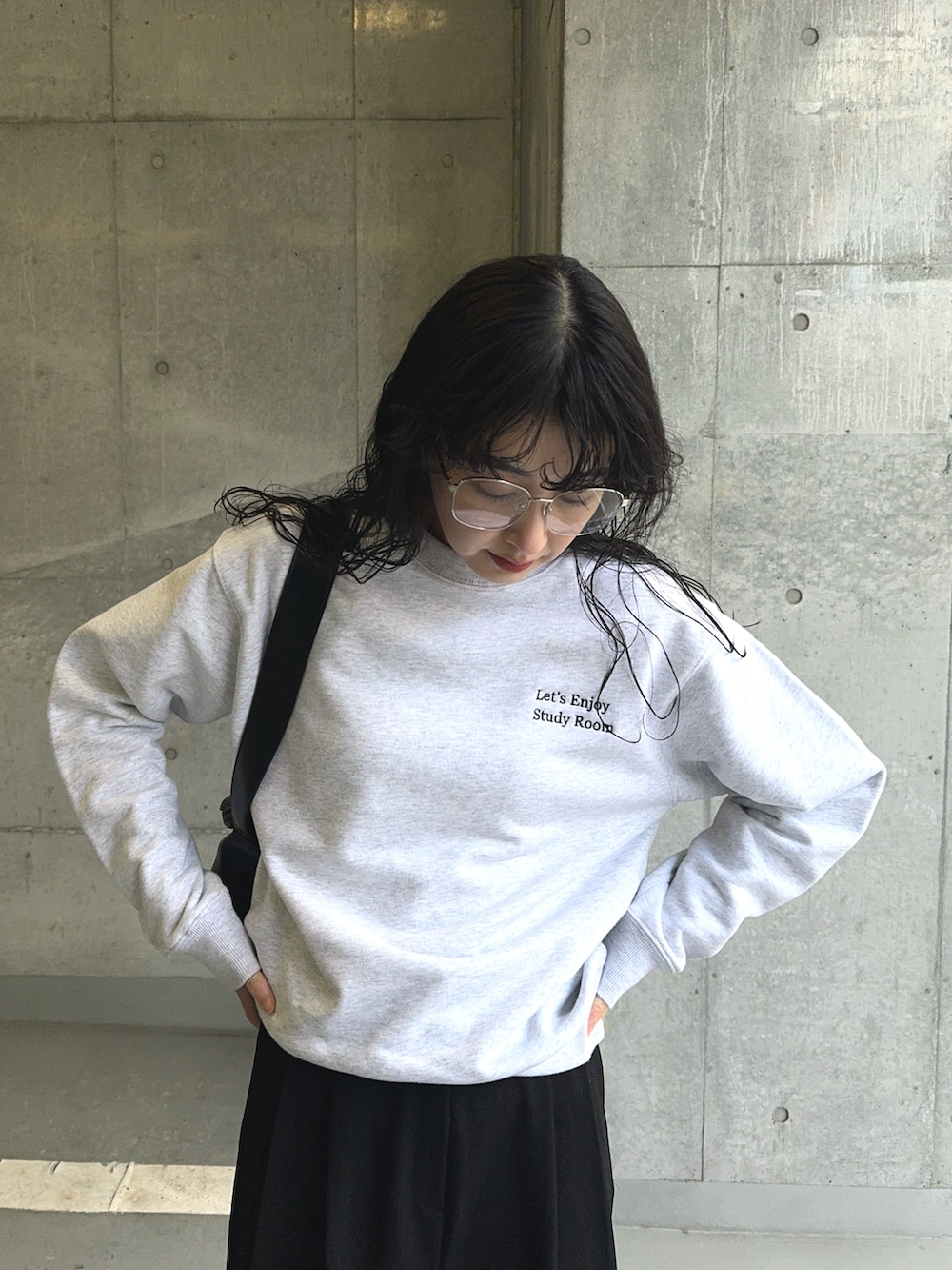 ホワイト系のスウェット、ブラック系のショルダーバッグ、ブラック系のスラックスを着用したレディースの春コーディネートの3枚目の写真