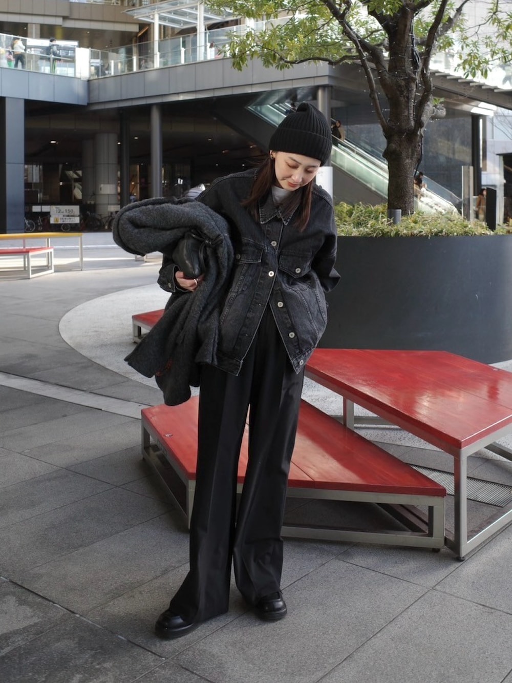 ブラック系のデニムジャケット、ブラック系のスラックス、ブラック系のローファーを着用したレディースの冬コーディネートの4枚目の写真