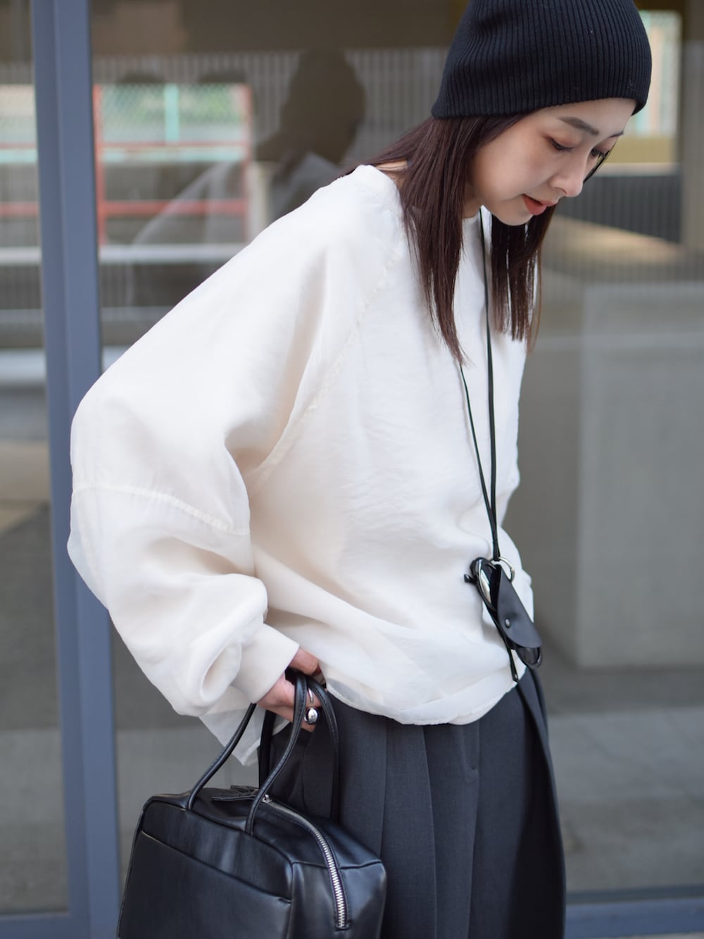 ホワイト系のTシャツ/カットソー、グレー系のその他パンツ、ブラック系のボストンバッグを着用したレディースの冬コーディネートの3枚目の写真