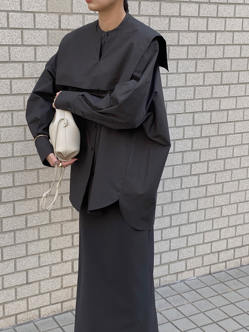 ブラック系のシャツ/ブラウス、グレー系のスニーカー、ホワイト系のショルダーバッグを着用したレディースの冬コーディネートの2枚目の写真