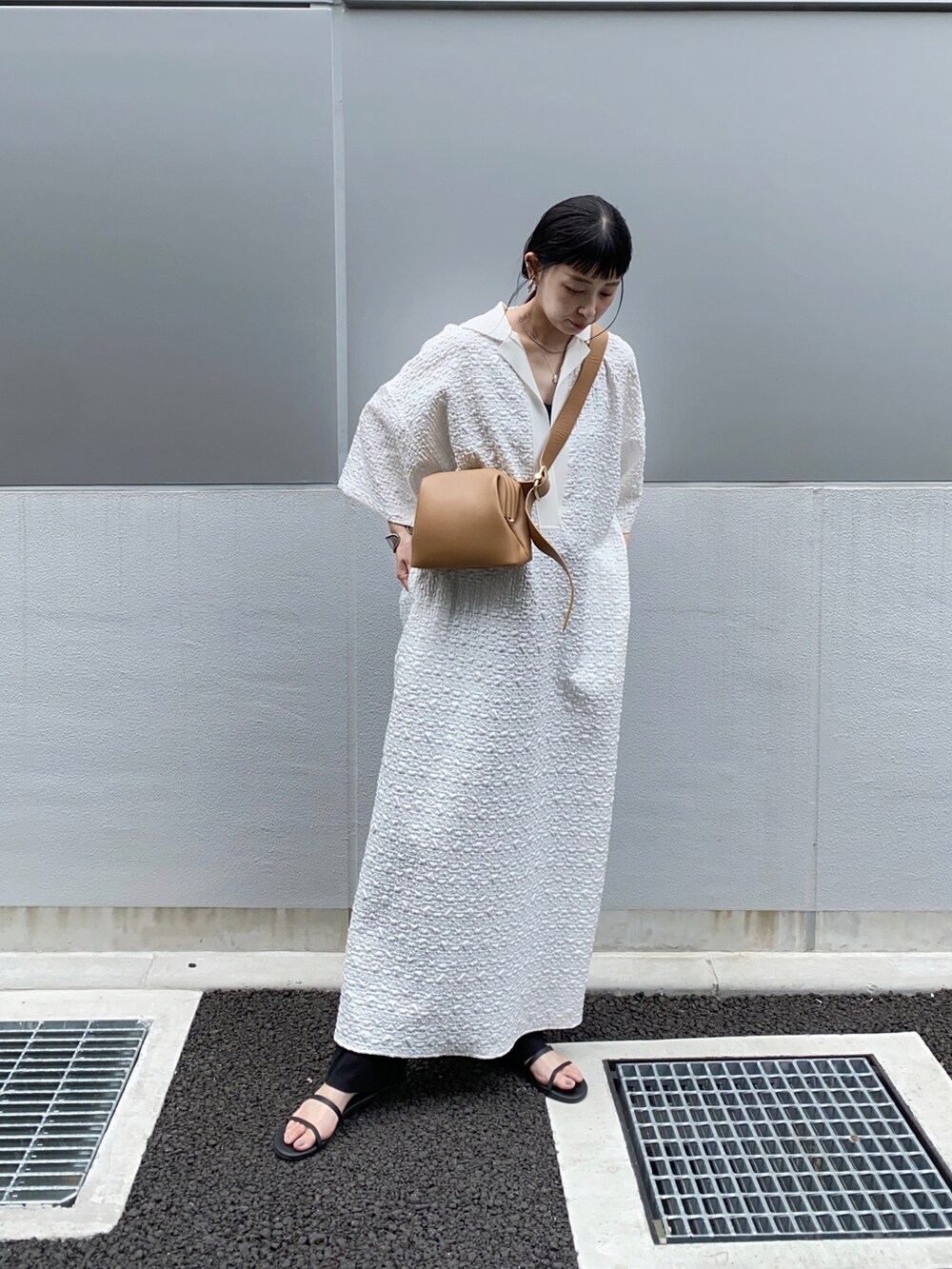 ホワイト系のワンピース、ブラウン系のショルダーバッグを着用したレディースの夏コーディネートの2枚目の写真