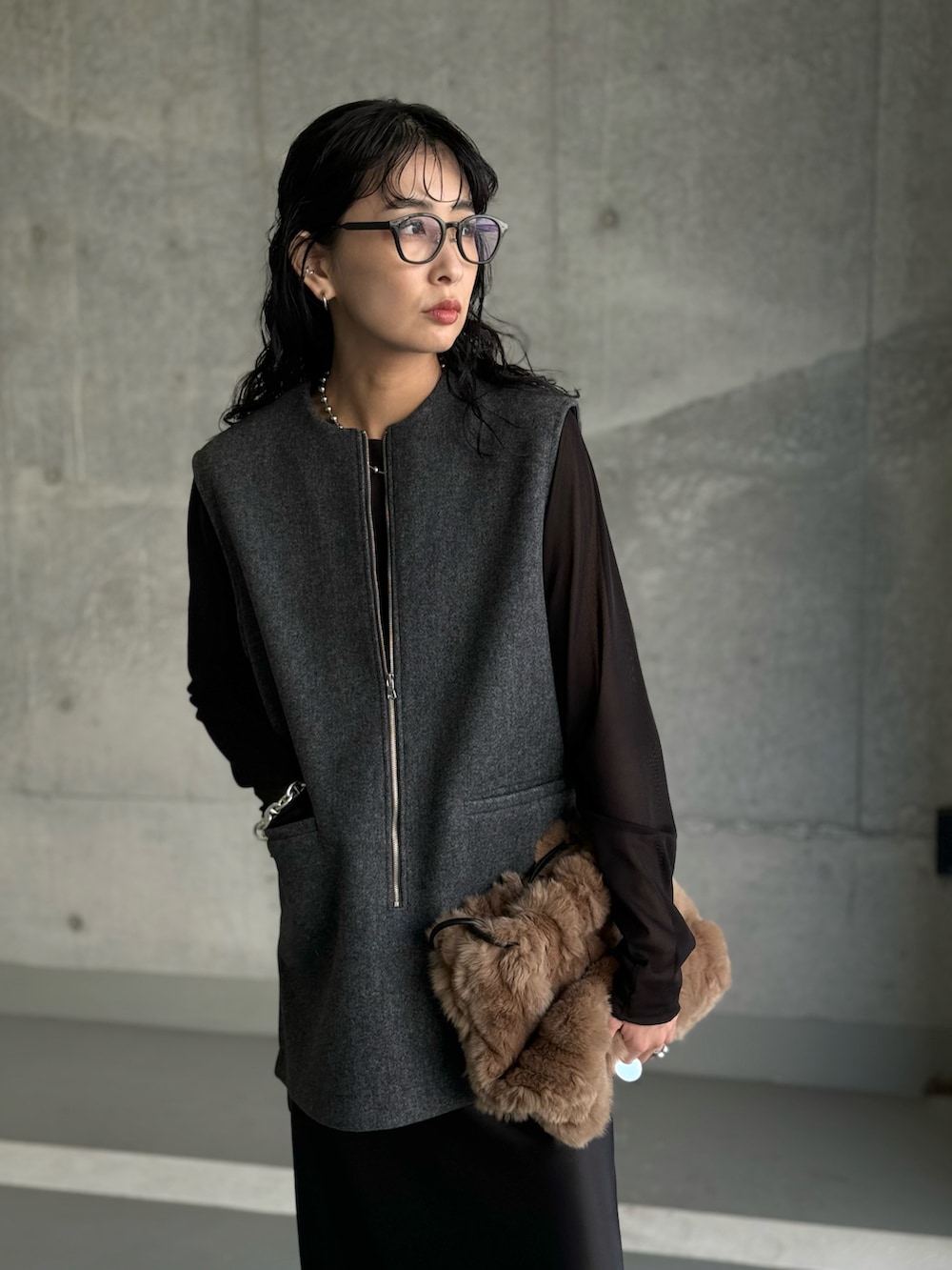 グレー系のベスト、ブラック系のTシャツ/カットソー、ブラック系のスカートを着用したレディースの秋コーディネートの2枚目の写真