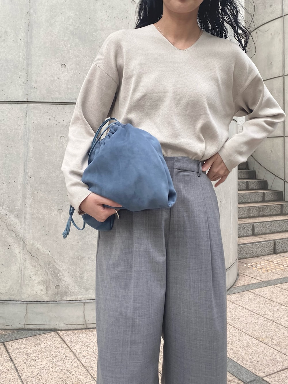 グレー系のニット/セーター、グレー系のスラックス、グレー系のスニーカーを着用したレディースの秋コーディネートの2枚目の写真