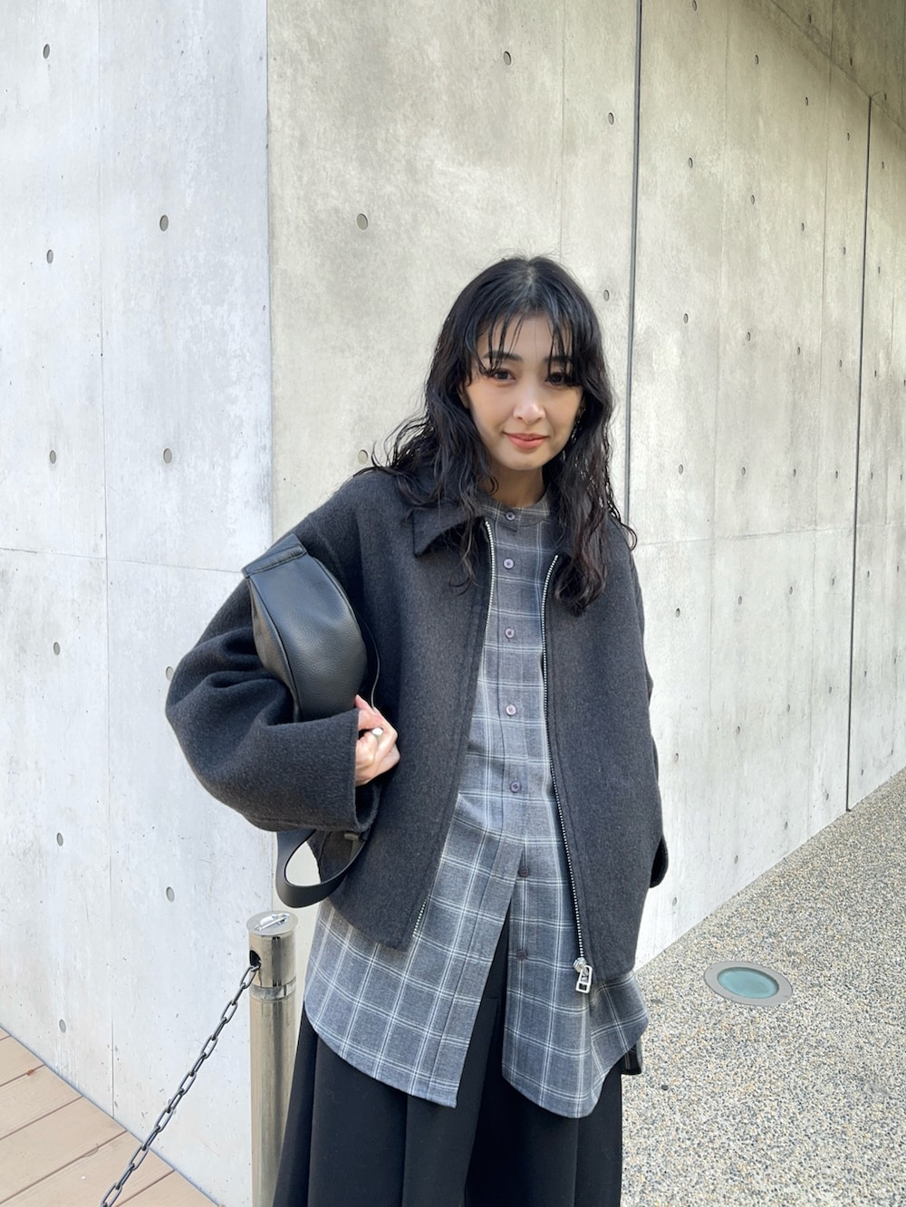 グレー系のブルゾン、グレー系のシャツ/ブラウス、ブラック系のスラックスを着用したレディースの冬コーディネートの3枚目の写真