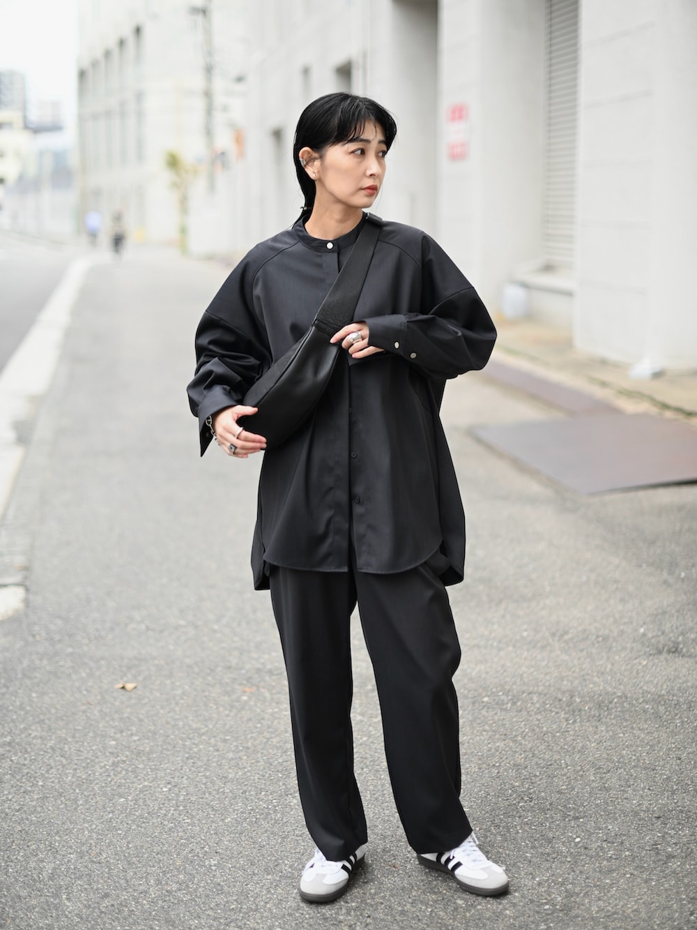 グレー系のシャツ/ブラウス、グレー系のスラックス、ホワイト系のスニーカーを着用したレディースの春コーディネートの2枚目の写真