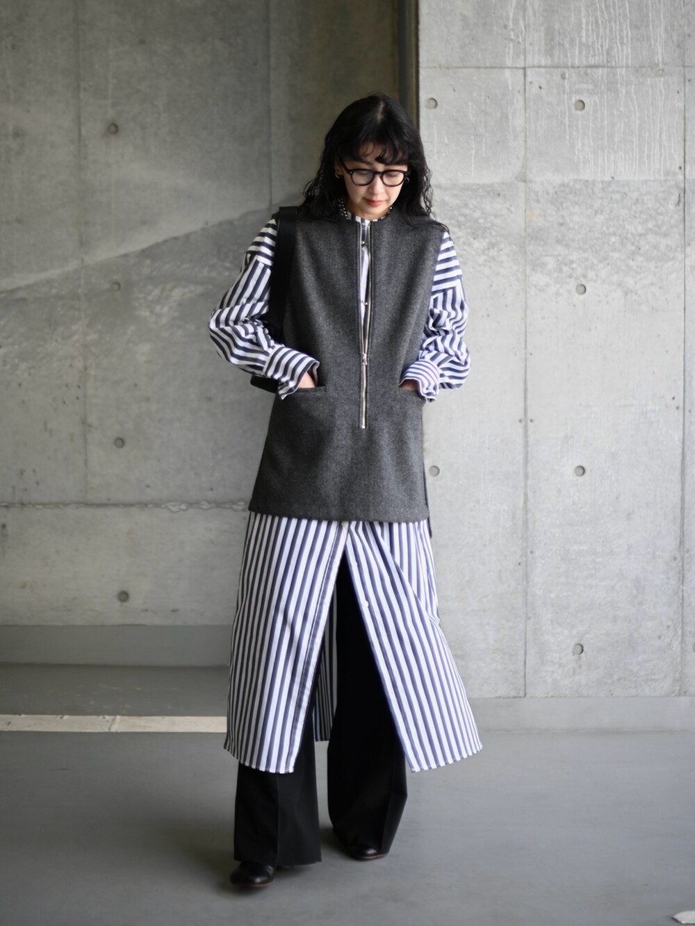 グレー系のベスト、その他のシャツワンピース、ブラック系のショルダーバッグを着用したレディースの冬コーディネートの2枚目の写真