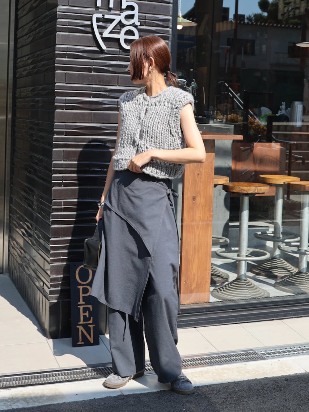 グレー系のスラックス、グレー系のスニーカー、ホワイト系のチューブトップを着用したレディースの秋コーディネートの5枚目の写真