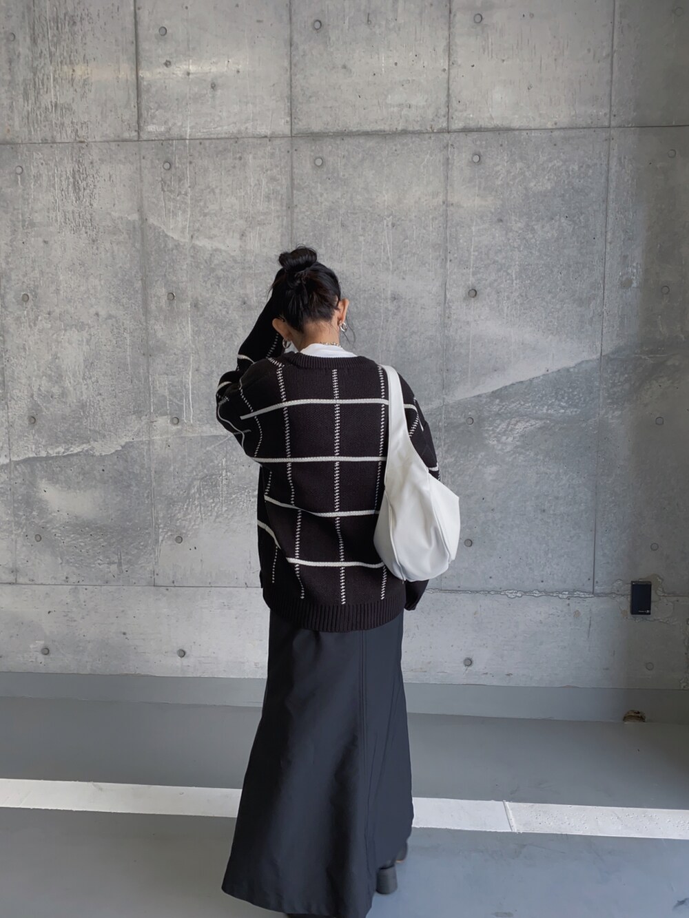 ブラック系のカーディガン/ボレロ、ブラック系のスカート、ホワイト系のトートバッグを着用したレディースの冬コーディネートの3枚目の写真