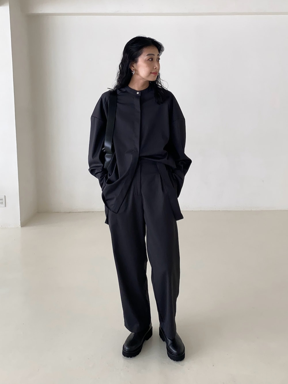 グレー系のシャツ/ブラウス、グレー系のスラックス、ブラック系のブーツを着用したレディースの春コーディネートの2枚目の写真