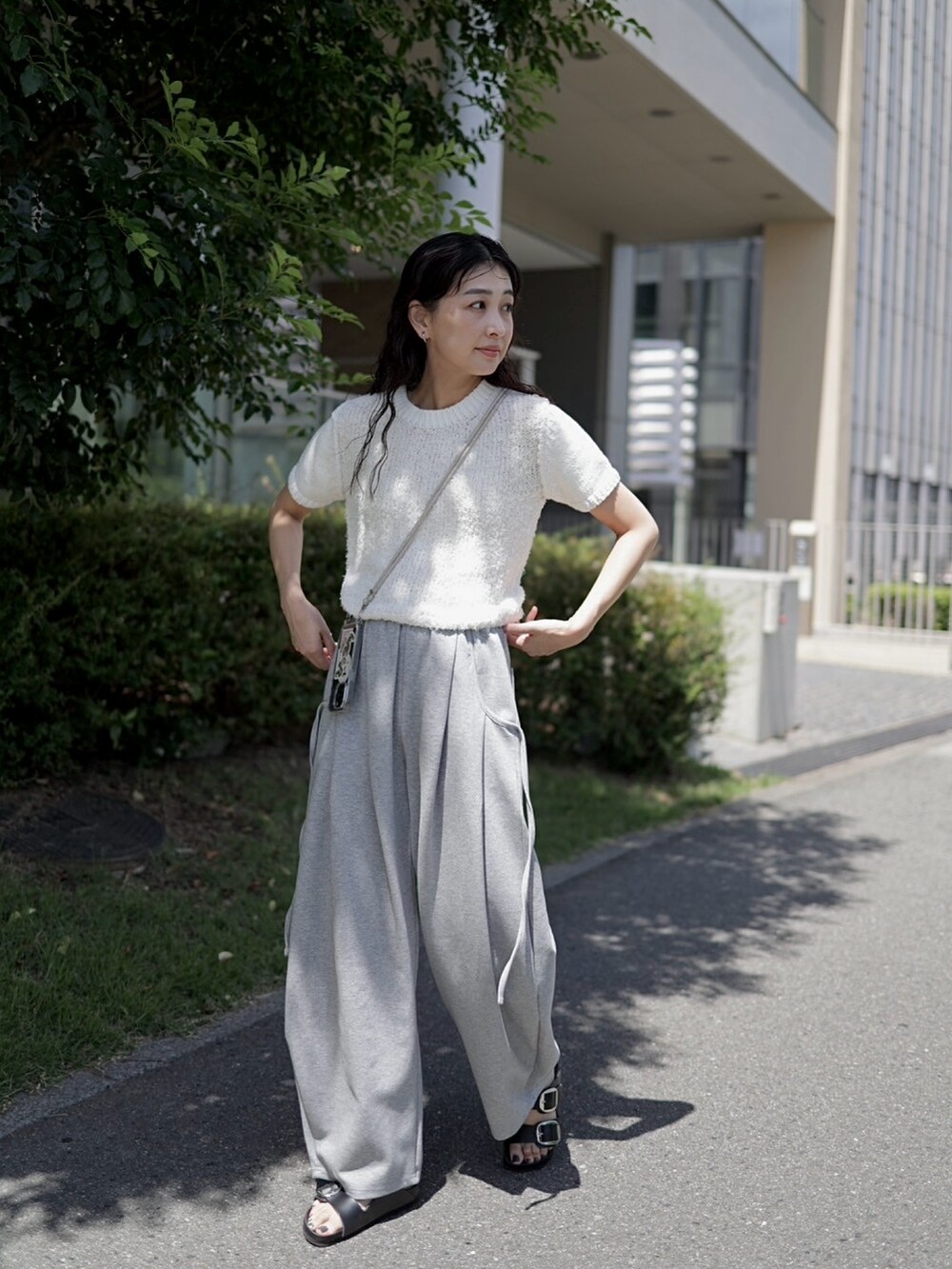 グレー系のスウェットパンツ、ホワイト系のニット/セーター、ブラック系のサンダルを着用したレディースの夏コーディネートの4枚目の写真