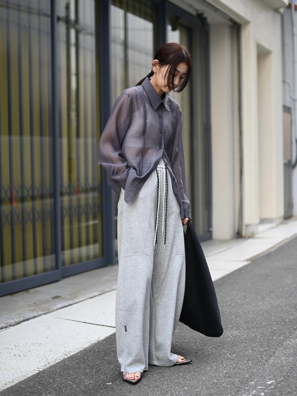 グレー系のシャツ/ブラウス、グレー系のスウェットパンツ、ブラック系のハンドバッグを着用したレディースの夏コーディネートの4枚目の写真