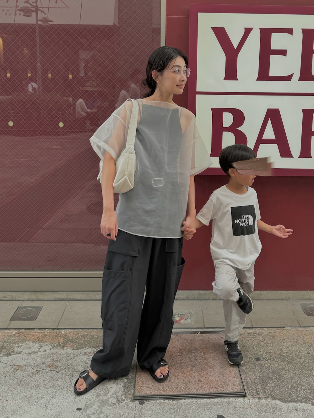 ホワイト系のシャツ/ブラウス、ブラック系のスラックス、ホワイト系のショルダーバッグを着用したレディースの夏コーディネートの2枚目の写真