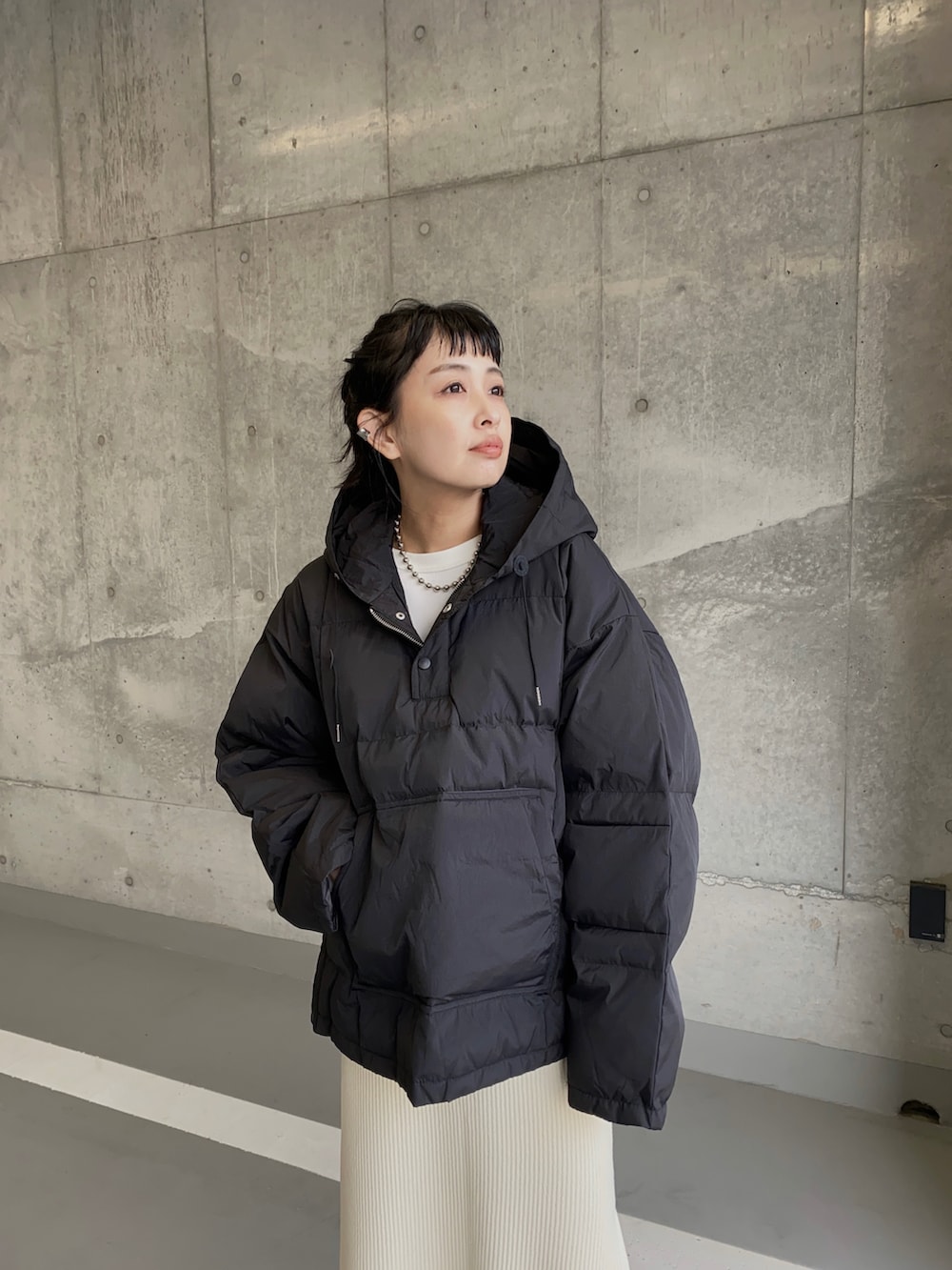 ブラック系のダウンジャケット/コート、ホワイト系のスカート、シルバー系のネックレスを着用したレディースの冬コーディネートの3枚目の写真