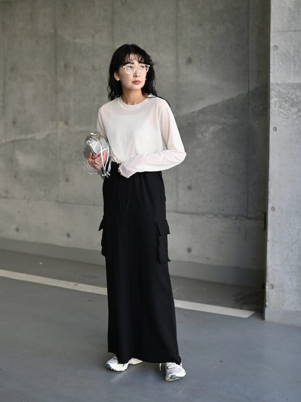 ホワイト系のTシャツ/カットソー、ブラック系のスカート、シルバー系のスニーカーを着用したレディースの夏コーディネートの5枚目の写真