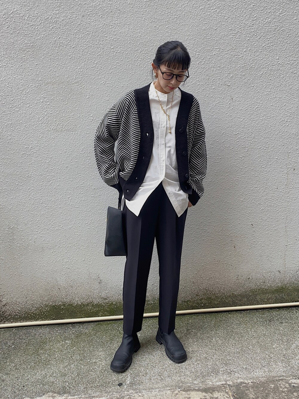 ホワイト系のシャツ/ブラウス、ブラック系のカーディガン/ボレロ、ゴールド系のネックレスを着用したレディースの冬コーディネートの2枚目の写真