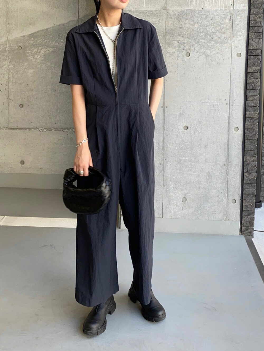 ブルー系のつなぎ/オールインワン、ホワイト系のタンクトップ、ブラック系のブーツを着用したレディースの夏コーディネートの3枚目の写真