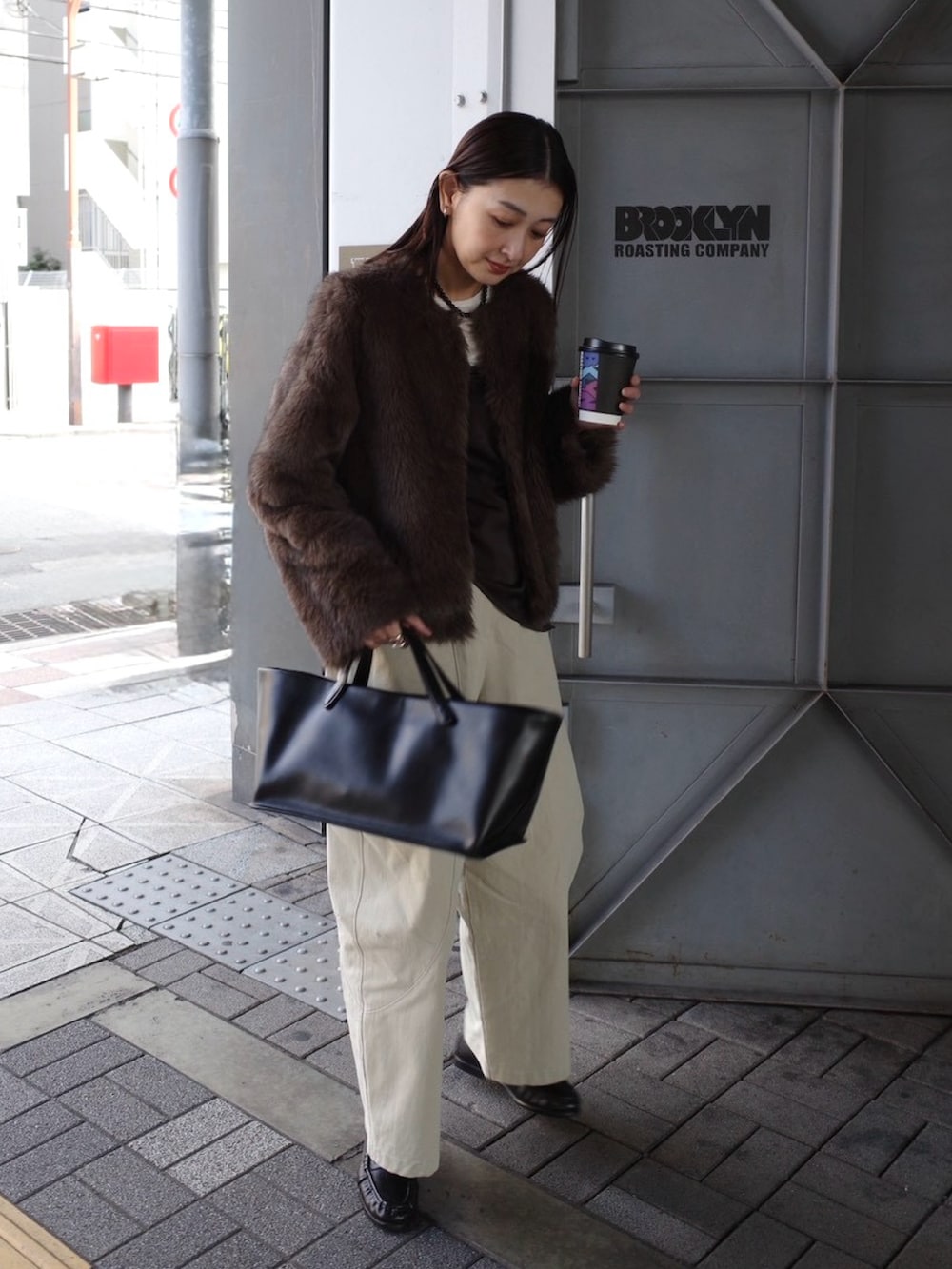 ベージュ系のチノパンツ、ブラウン系のノーカラージャケット、ブラック系のトートバッグを着用したレディースの秋コーディネートの5枚目の写真