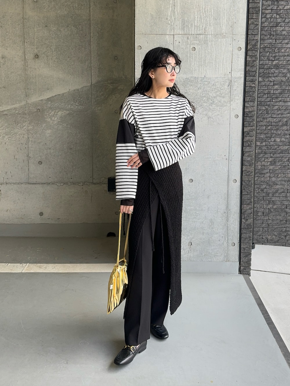 ブラック系のTシャツ/カットソー、ブラック系のスカート、ゴールド系のショルダーバッグを着用したレディースの春コーディネートの3枚目の写真