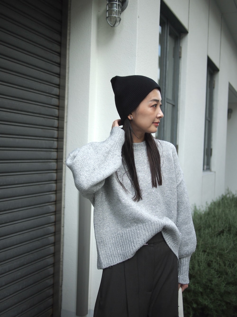 グレー系のニット/セーター、ホワイト系のショルダーバッグ、グレー系のパンツを着用したレディースの秋コーディネートの3枚目の写真