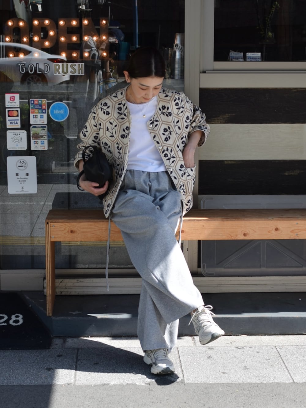 ベージュ系のノーカラージャケット、シルバー系のスニーカーを着用したレディースの春コーディネートの3枚目の写真