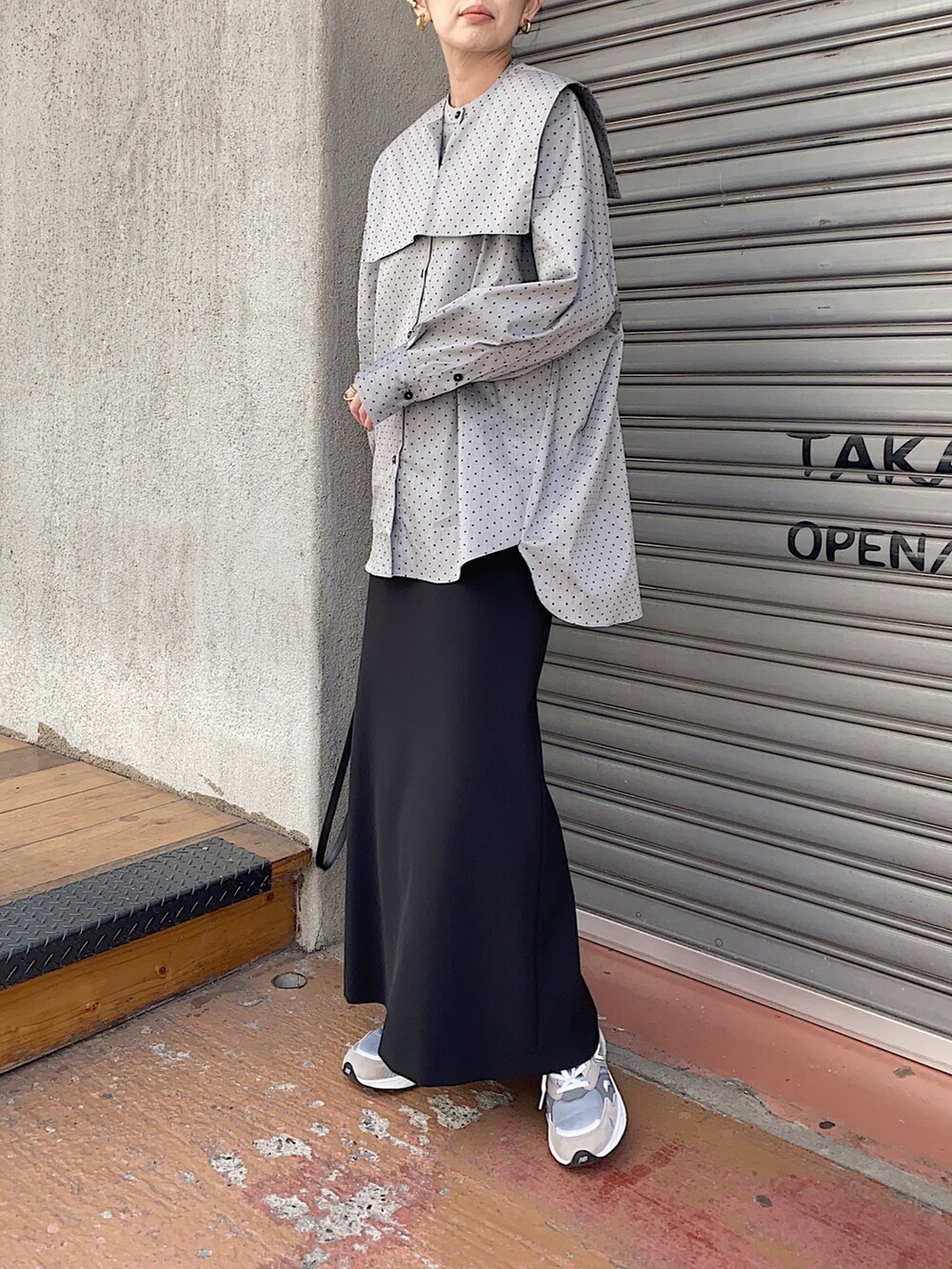 ブラック系のシャツ/ブラウス、ブラック系のショルダーバッグ、グレー系のスニーカーを着用したレディースの春コーディネートの2枚目の写真