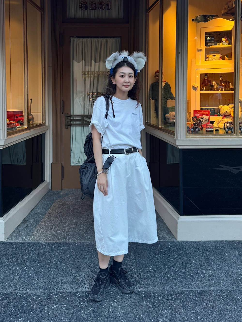ホワイト系のTシャツ/カットソー、ホワイト系のパンツ、ブラック系のバックパック/リュックを着用したレディースの夏コーディネートの4枚目の写真