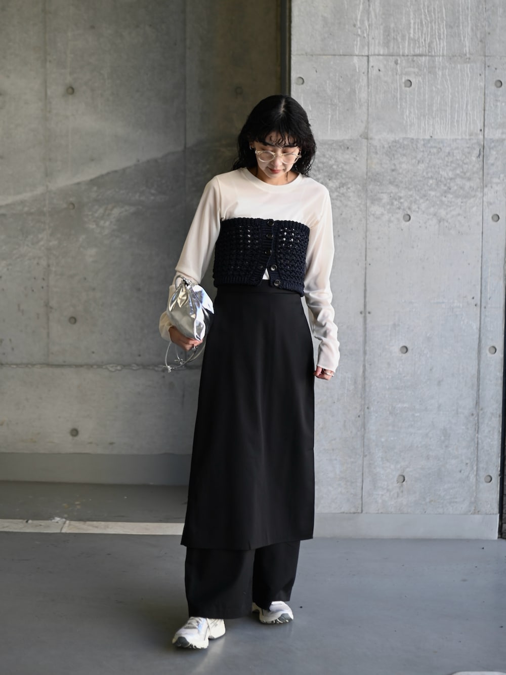 ブルー系のニット/セーター、ブラック系のスラックス、シルバー系のスニーカーを着用したレディースの春コーディネートの2枚目の写真