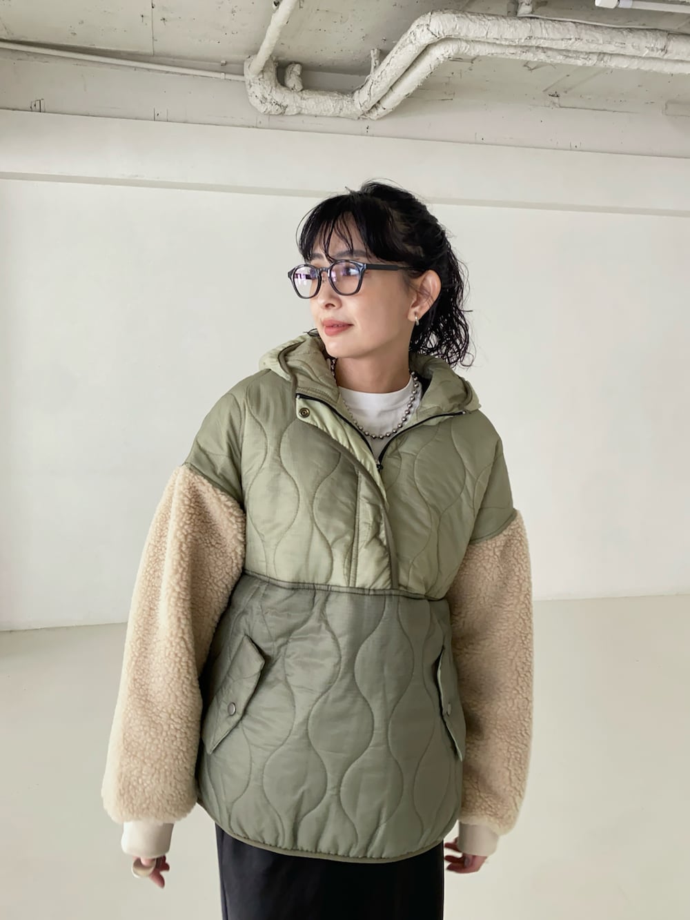 グリーン系のダウンジャケット/コート、ブラック系のブーツ、シルバー系のネックレスを着用したレディースの秋コーディネートの3枚目の写真