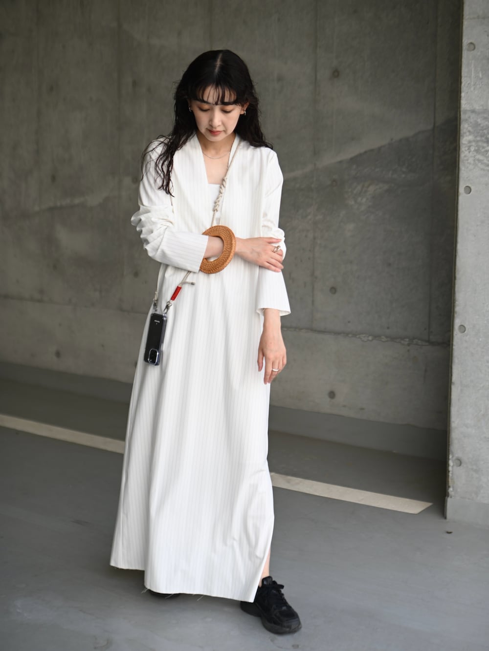 ホワイト系のワンピース、ブラック系のスニーカー、ブラック系のキャミソールを着用したレディースの春コーディネートの2枚目の写真