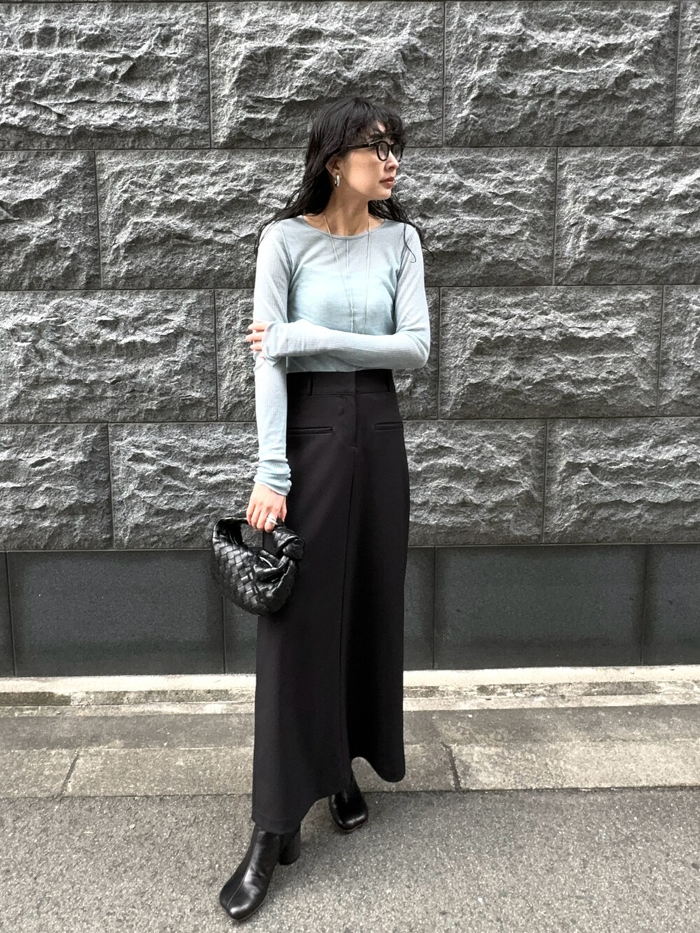 ブラック系のスカート、ブラック系のブーツ、ブラック系のメガネを着用したレディースの春コーディネートの3枚目の写真