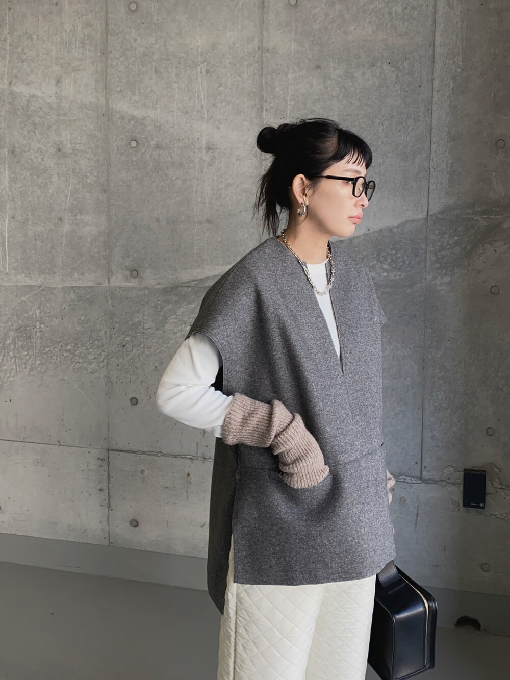 グレー系のベスト、ホワイト系のその他パンツ、ホワイト系のTシャツ/カットソーを着用したレディースの冬コーディネートの3枚目の写真