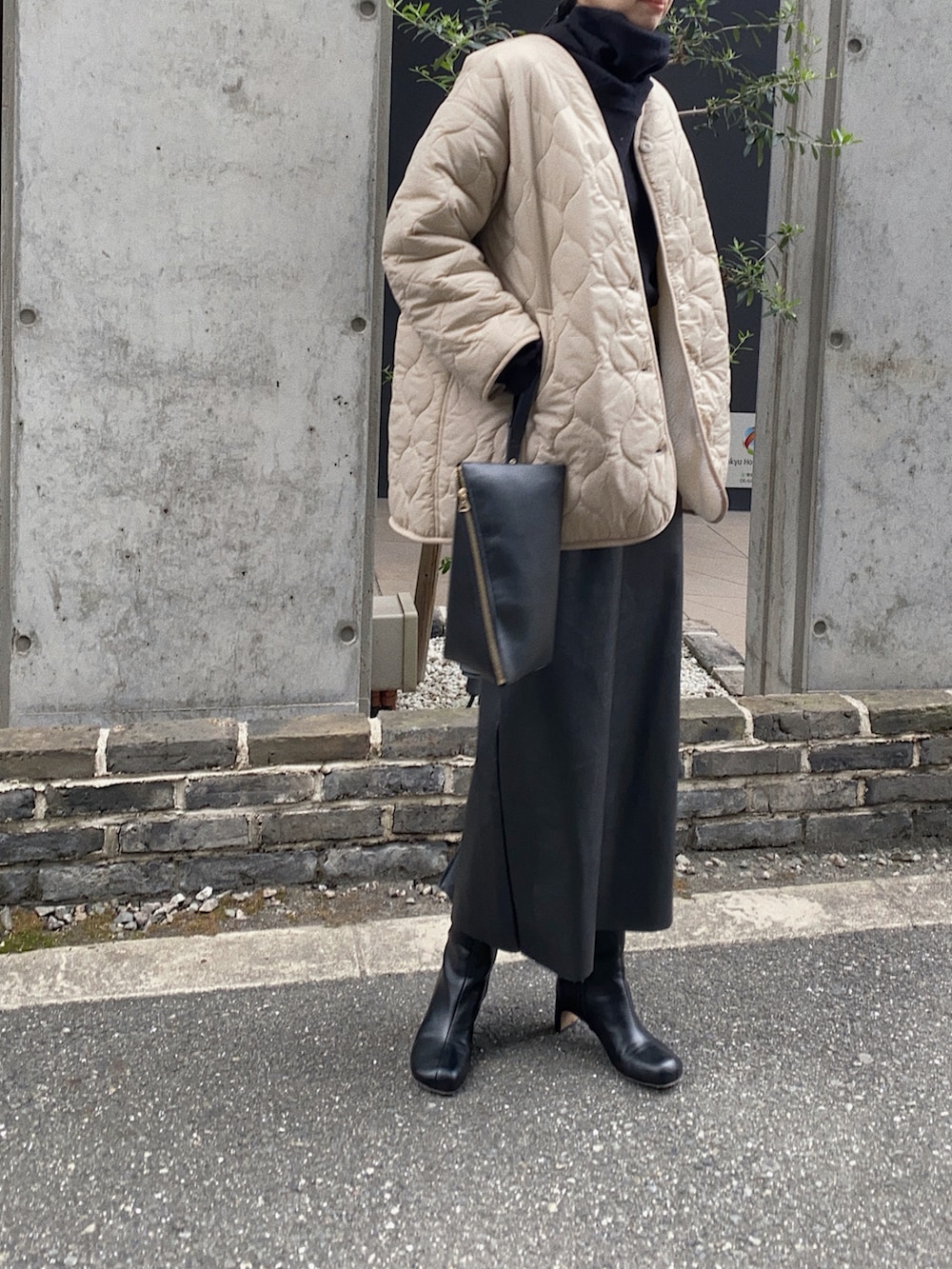 ベージュ系のブルゾン、ブラック系のニット/セーター、ブラック系のショルダーバッグを着用したレディースの秋コーディネートの2枚目の写真