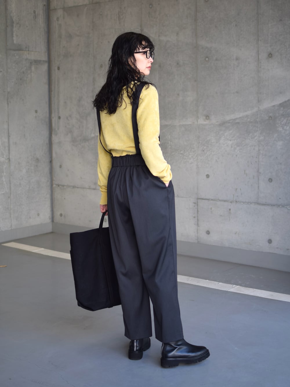 グレー系のブルゾン、イエロー系のカーディガン/ボレロ、グレー系のスラックスを着用したレディースの冬コーディネートの3枚目の写真