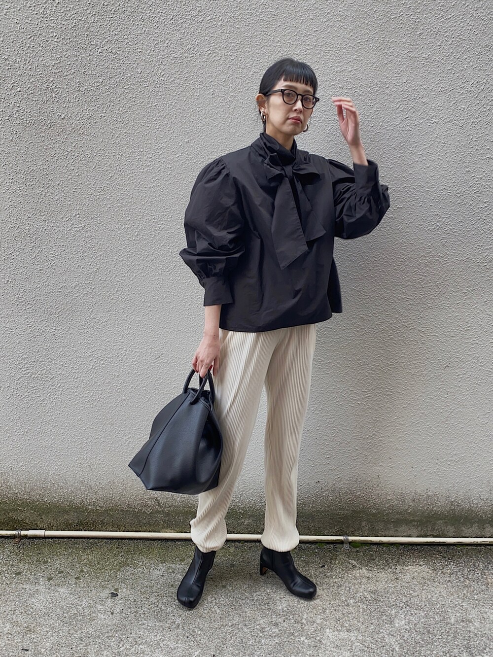 ブラック系のシャツ/ブラウス、ホワイト系のその他パンツ、ブラック系のハンドバッグを着用したレディースの冬コーディネートの3枚目の写真