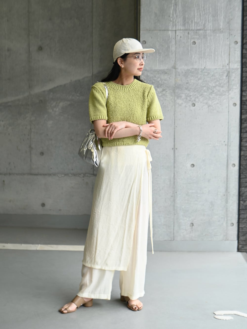グリーン系のニット/セーター、ホワイト系のその他パンツ、ブラウン系のサンダルを着用したレディースの夏コーディネートの4枚目の写真
