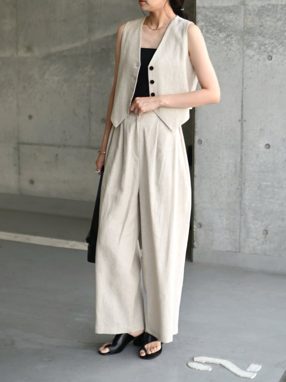 ベージュ系のベスト、ベージュ系のその他パンツ、ブラック系のショルダーバッグを着用したレディースの夏コーディネートの2枚目の写真